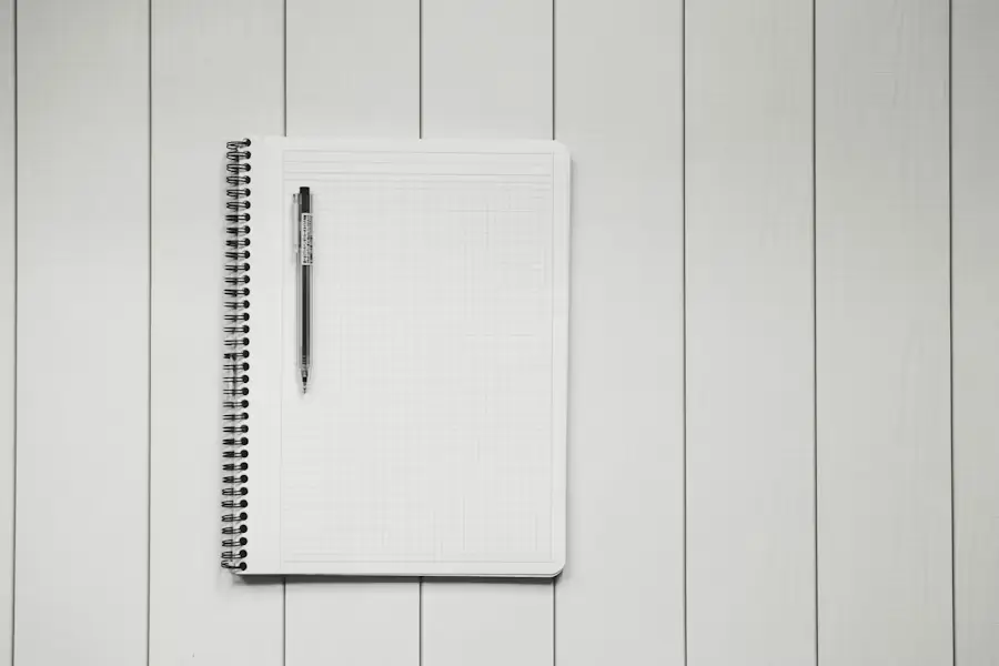 Bureau d'étudiant avec ordinateur portable, lampe et carnet de notes ouvert