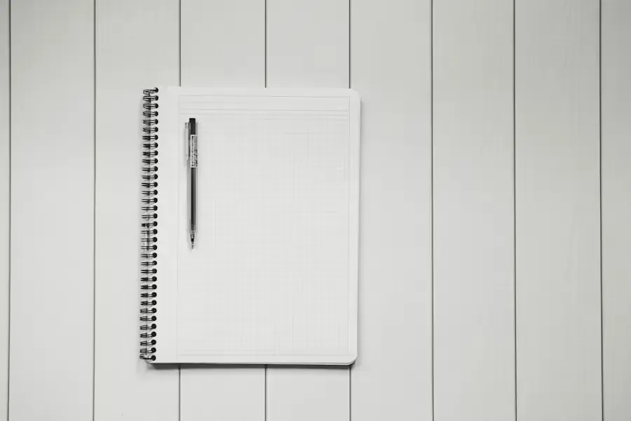 Bureau d'étudiant avec ordinateur portable, lampe et carnet de notes ouvert